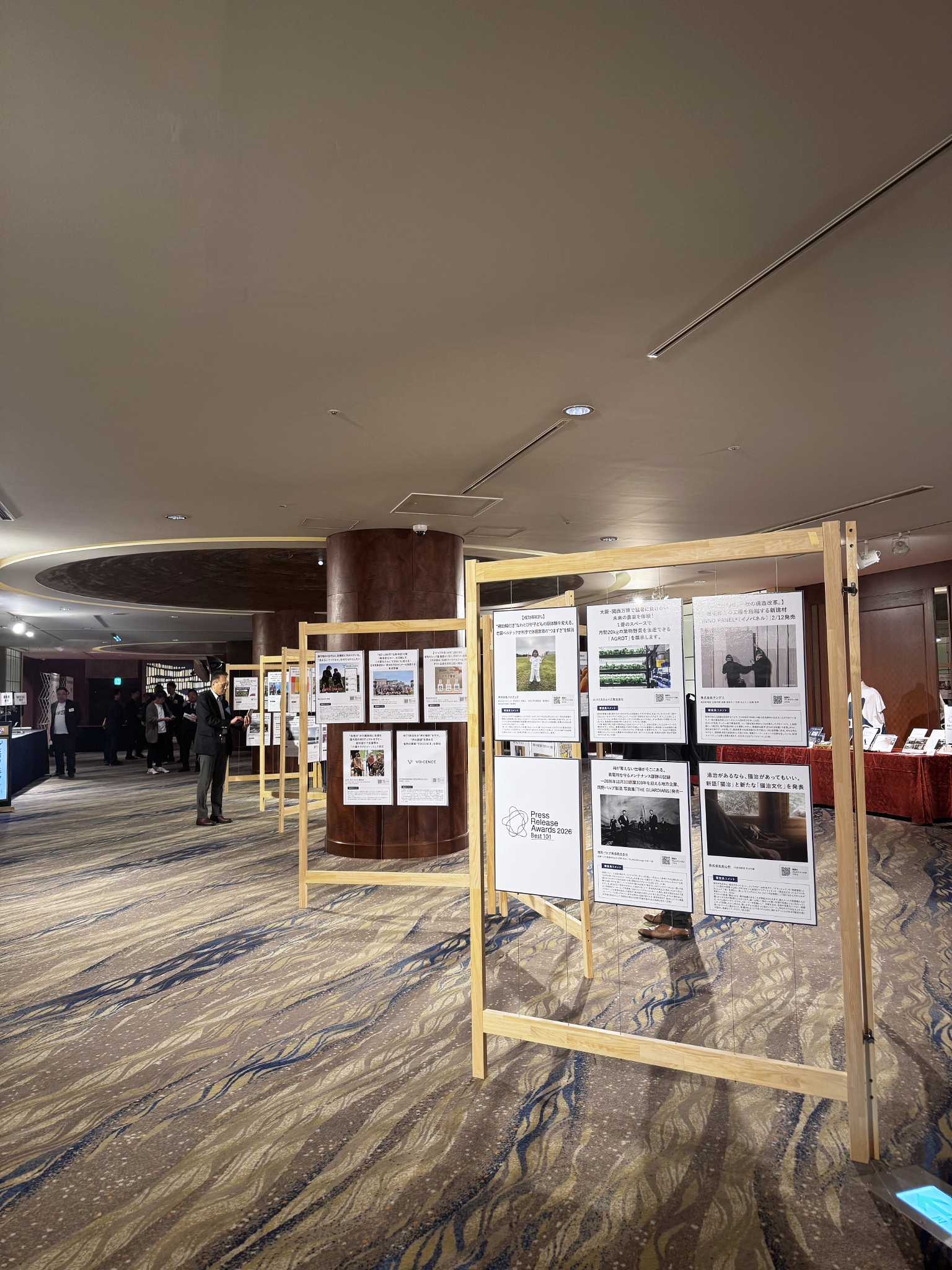 木製の展示枠にBest101選出稿のパネルが並ぶ会場と、手前右下に展示された和心村のパネル